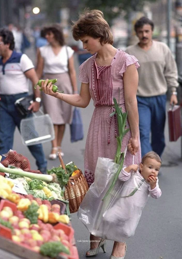 mother holding her daughter at a budapest market in 1987